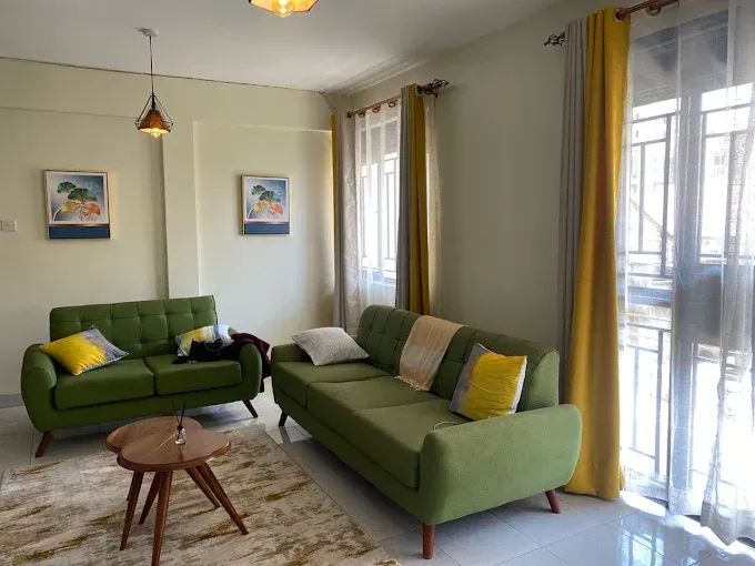 Bright apartment lounge with green sofas